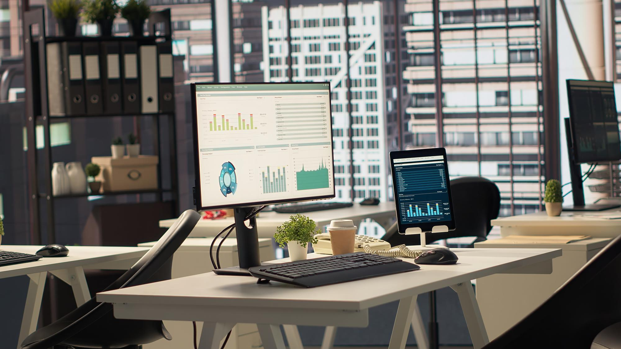Modern business workspace with software dashboards on desktop screens